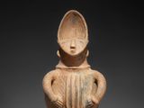 an image of a clay figurine of a woman with a hat on her head
