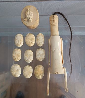 a display case with a wooden figure and a lot of buttons