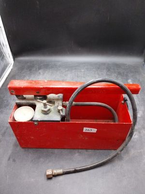 une boîte à outils rouge contenant un tuyau