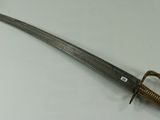 a close up of a sword on a table with a white background