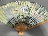 a green and white fan on a gray table