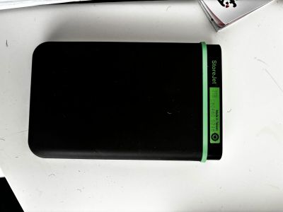 une batterie externe noire posée sur une table à côté d'un clavier