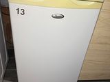 a small white refrigerator in the corner of a kitchen