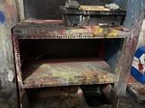 a rusted metal work bench in a dirty room