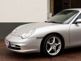 silver sports car parked in front of a building on a sidewalk