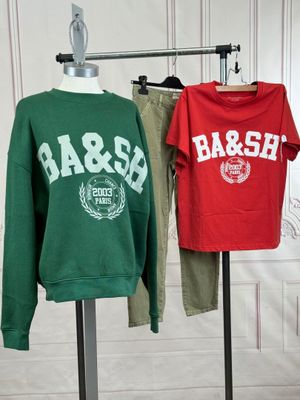 two sweatshirts on a mannequin stand in front of a white wall