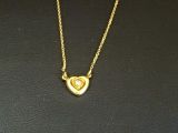 un gros plan d'un collier en or orné d'un cœur