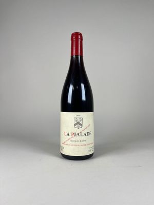 a bottle of red wine sitting on top of a white table