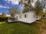 une photo d'un mobil-home dans l'herbe