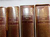 trois livres sont alignés les uns à côté des autres sur une étagère