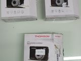 three boxes of digital cameras sitting on top of a glass table