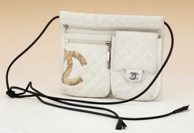 a white purse that has a gold logo on it