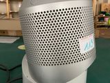 a white and gray speaker sitting on a green table