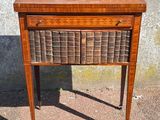 a small wooden table with a basket on top of it