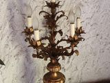 a gold chandelier with five lights on it on a table