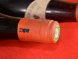 two bottles of wine sitting on a red table