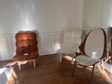 deux chaises dans une pièce où un miroir est accroché au mur
