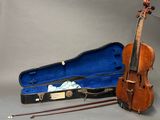 a violin and a violin case on a grey background