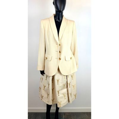 Le mannequin porte un tailleur-jupe orné d'étoiles dorées.