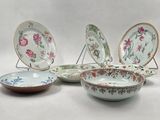 several plates and bowls are sitting on a stand on a white surface