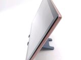 a tablet computer sitting on a stand on a white surface