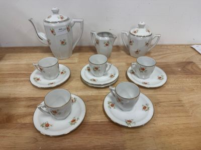 six cups and saucers and a teapot on a table