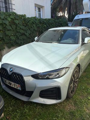 La BMW blanche est garée devant une maison.