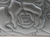 a close up of a purse with a rose design on it