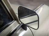 reflection of a car ' s side mirror on the side of a white car