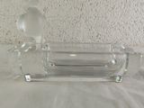 a glass bird sitting on top of a glass container