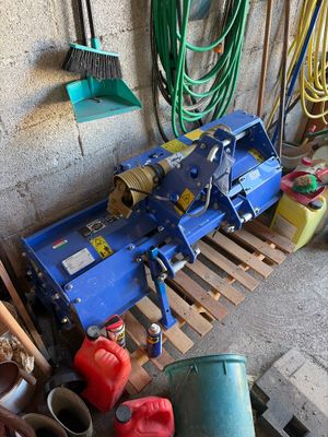 a blue machine that is sitting on a pallet in a garage