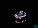 a close up of a purple diamond on a black surface