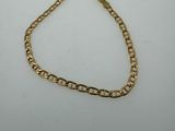 a gold chain bracelet on a white background