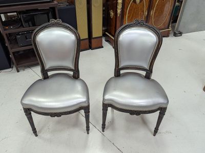 pair of silver chairs in a room with a wooden floor