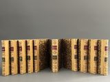 six livres sont empilés les uns sur les autres sur une surface grise