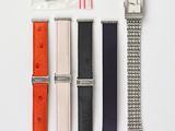 three different watches and a watch strap on a white surface