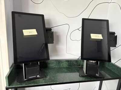 deux écrans d'ordinateur posés sur un bureau au plateau vert