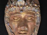 an image of a bronze mask on a black background