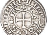 a silver coin with a cross on the front of it