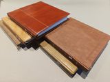 three leather bound books stacked on top of each other on a table