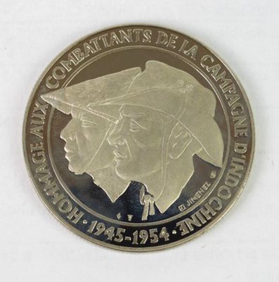 a silver coin with a picture of a man and a woman on it