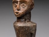 une statue en bois représentant une femme tenant un bébé dans ses bras