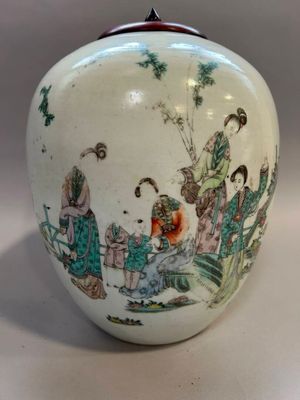 un vase blanc avec un tableau posé sur une table