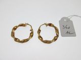 une paire de boucles d'oreilles créoles en or avec son étiquette de prix