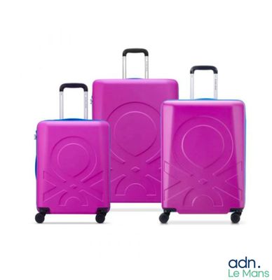 trois bagages roses posés sur une surface blanche