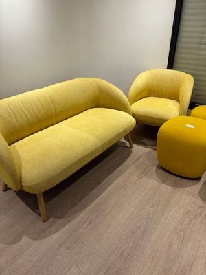 deux chaises jaunes et un pouf jaune dans une pièce