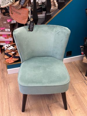 une chaise posée devant une pile de sacs à main