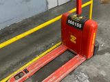 un chariot élévateur rouge garé devant un bâtiment
