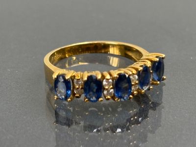 an image of a gold ring with blue sapphires and diamonds