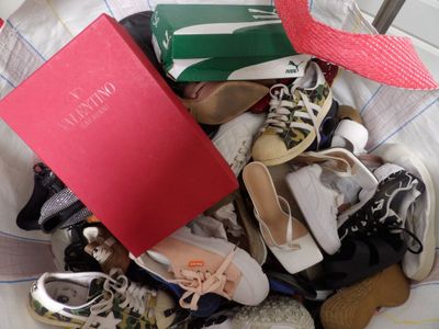 une pile de chaussures et un livre sur un lit